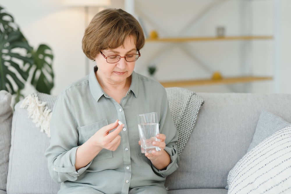 A middle aged woman taking pain medication 